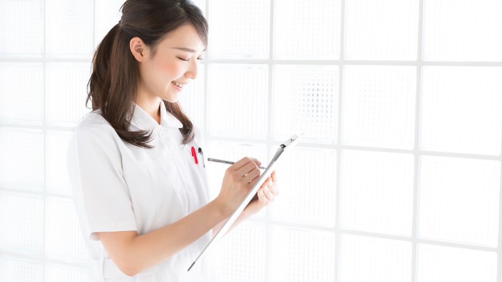 やりがいに満ちた笑顔で記録を取る看護師