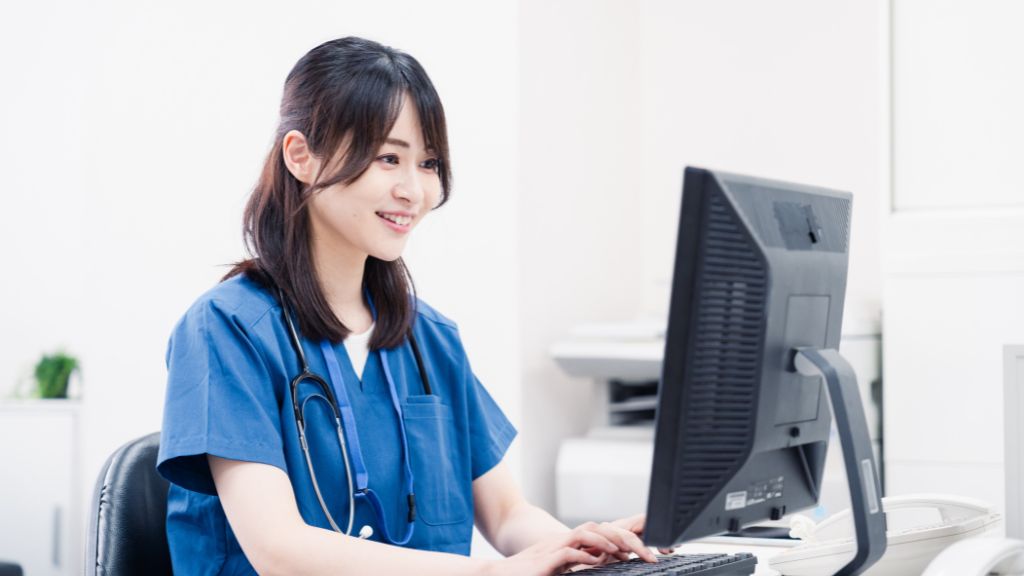笑顔でカルテ入力をする女性