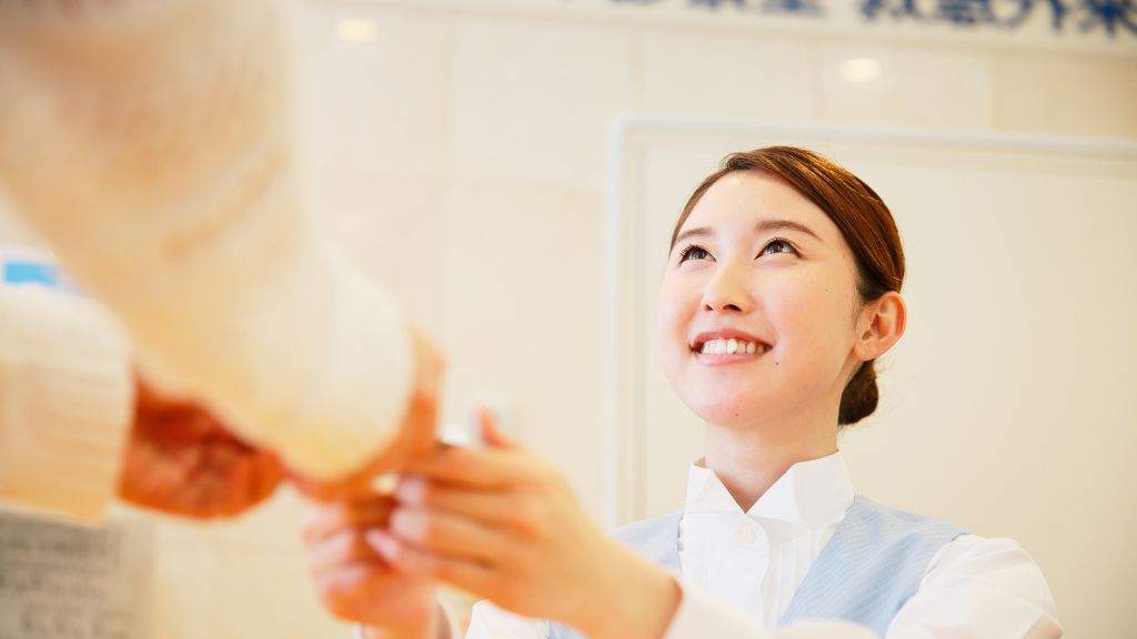 手を握る受付スタッフ