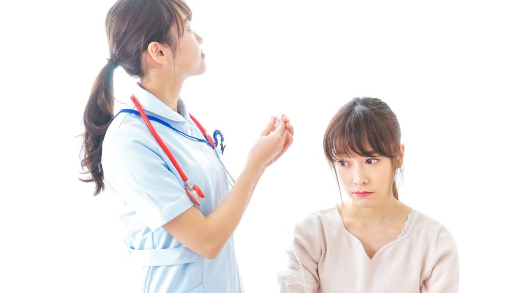 看護師とうつむく患者