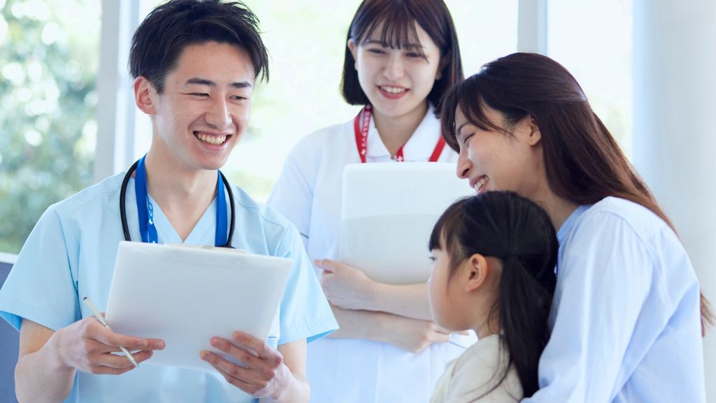 子どもと母親に笑顔で応対する医師と看護師